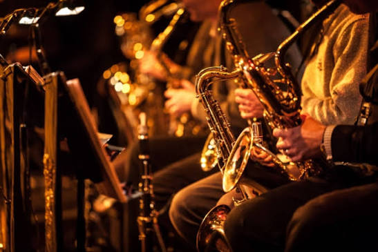 es musiciens de jazz se produisant en plein air dans un cadre tropical.